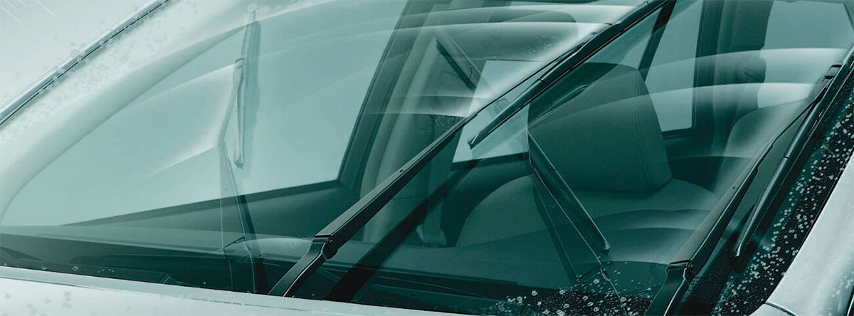 Pare-brise d’une voiture parfaitement propre avec les essuie-glaces en fonctionnement