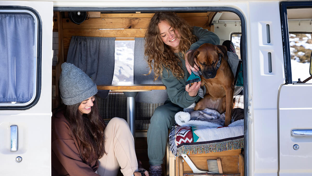 Deux femmes et un chien à l’intérieur d’une caravane
