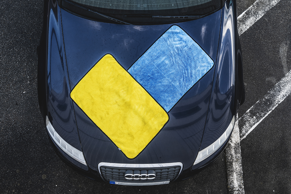 Serviettes de séchage pour voiture posées sur le capot d’une Audi de couleur sombre