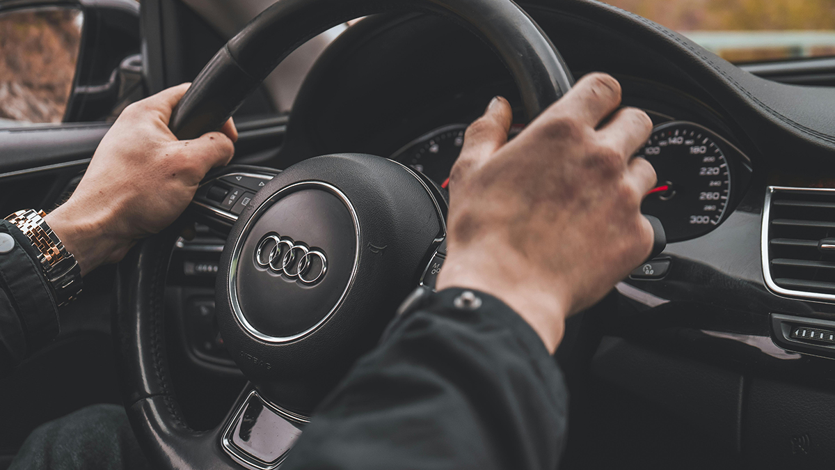 Mains d’un homme tenant le volant d’une voiture Audi