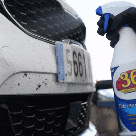 Persona pulverizando 361 Todo Uso Coche sobre la defensa llena de mosquitos de un coche blanco