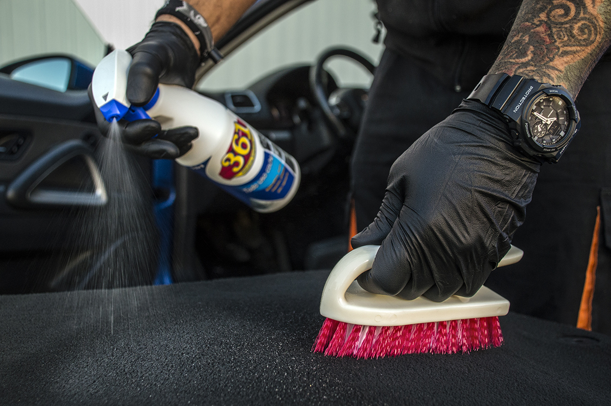 Homme nettoyant un siège avec un produit 361 Todo Uso Coche et une brosse pour tapisserie